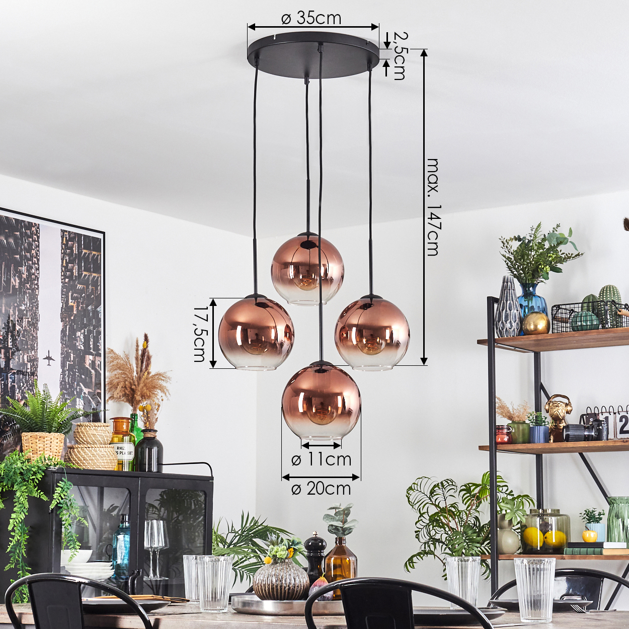 Esszimmer mit Hängelampe mit vier kupferfarbenen Glaskugeln. Es gibt Pflanzen, Gläser und einen Holztisch.