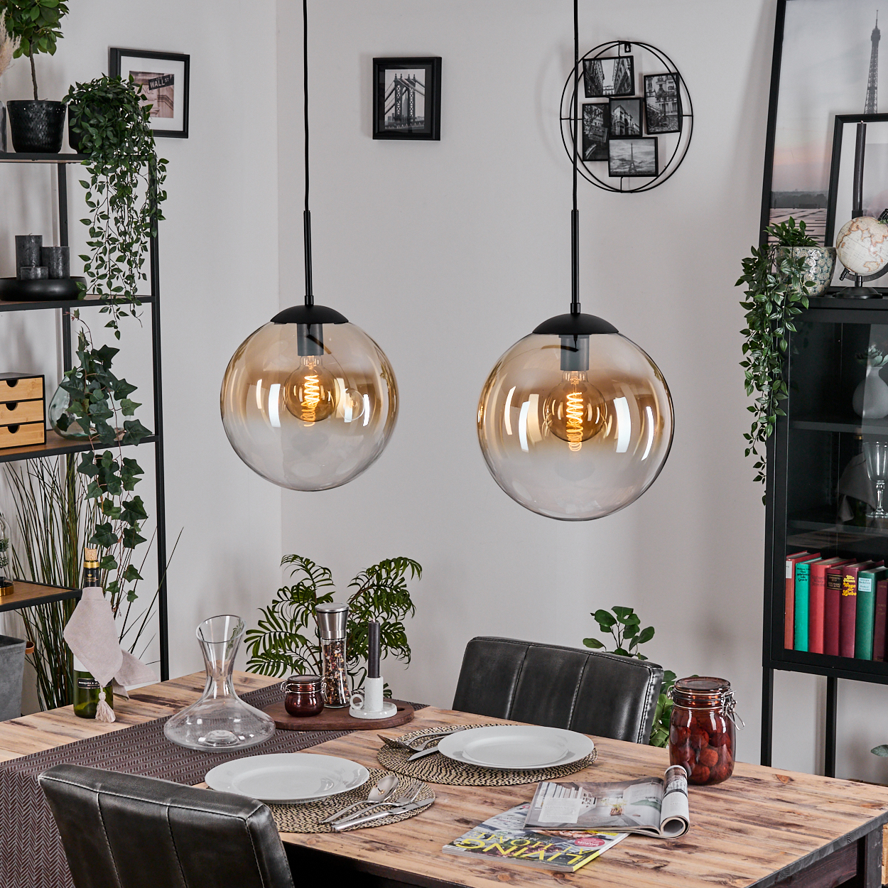 Esszimmer mit Holztisch, Glaslampen und dekorativen Regalen. Tisch mit Tellern, Besteck und einem Glas mit Essen. Pflanzen verschönern die Dekoration.