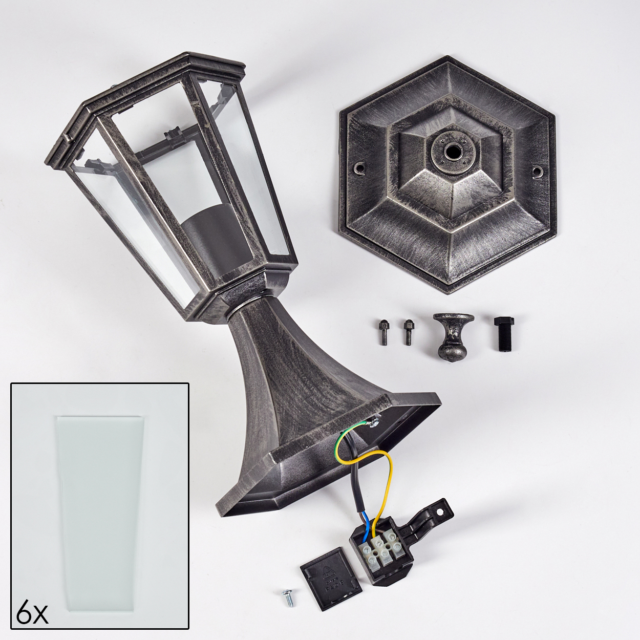 Zerlegte Außenlampe. Enthält Lampe, Sockel, Glasscheiben, Schrauben und elektrische Komponenten. Metallfarbe auf weißem Hintergrund.