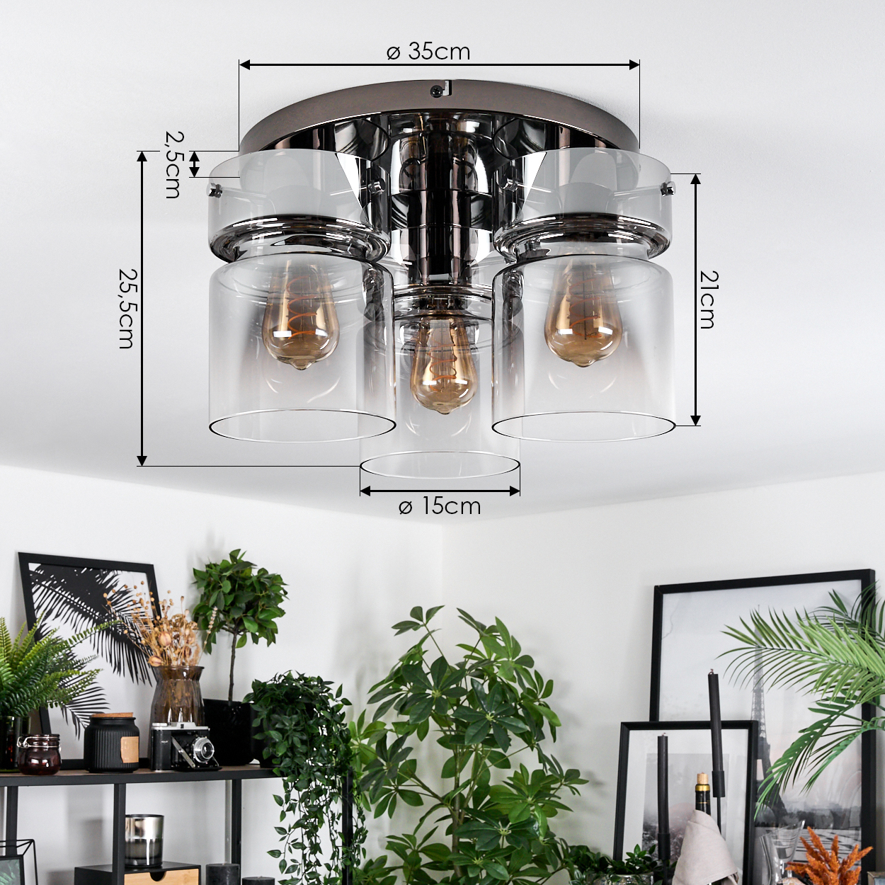 Deckenlampe mit drei Glasschirmen. Maße sind 35 cm, 25,5 cm, 21 cm und 15 cm. Pflanzen und Dekoration im Hintergrund.