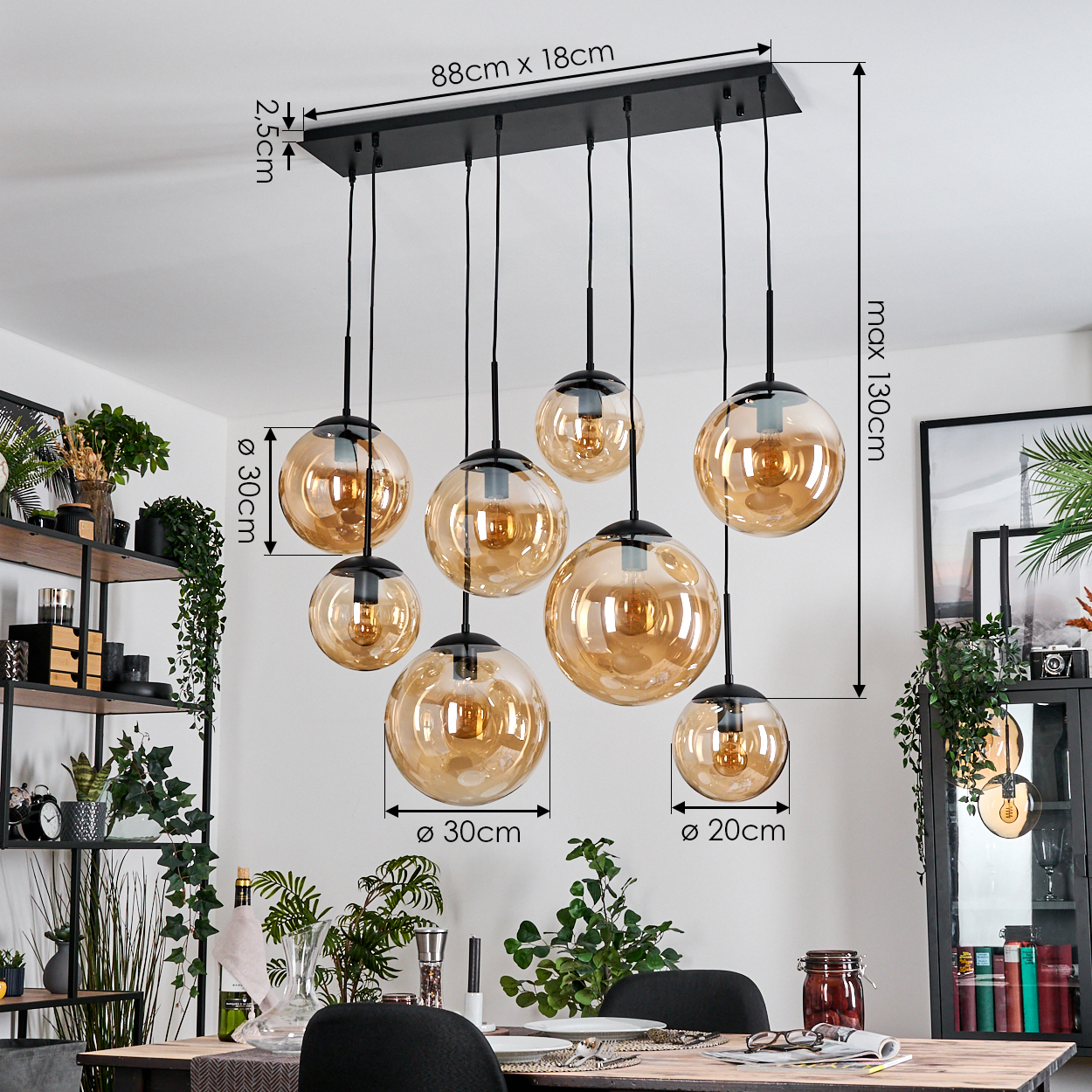 Eine moderne Esszimmer-Hängeleuchte mit bernsteinfarbenen Glaskugeln. Sie hängt über einem Holztisch, und der Raum hat Pflanzen und Dekorationen.