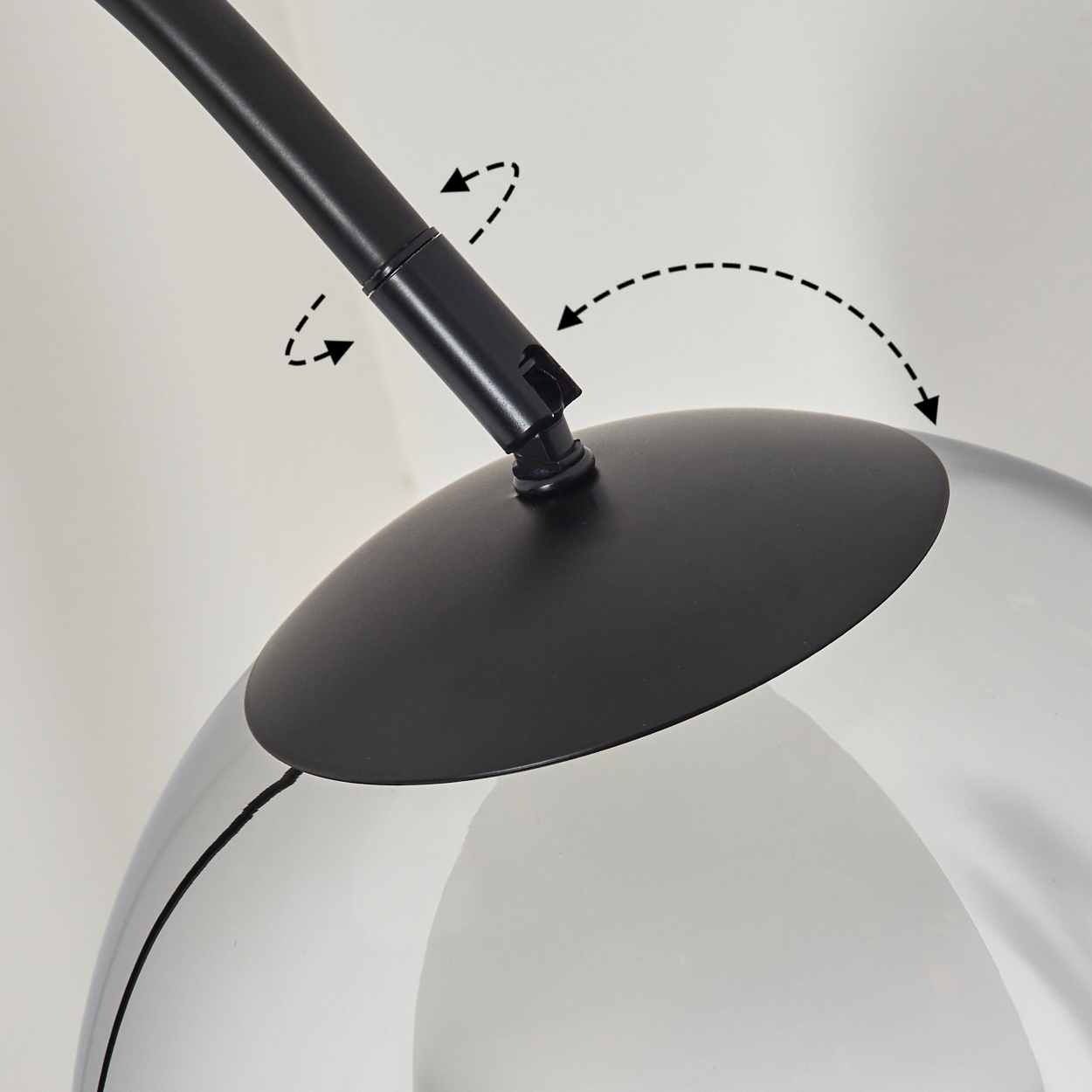 Nahaufnahme einer schwarzen Lampe mit klarem Glasschirm. Pfeile zeigen die Einstellpunkte an. Der Hintergrund ist weiß.