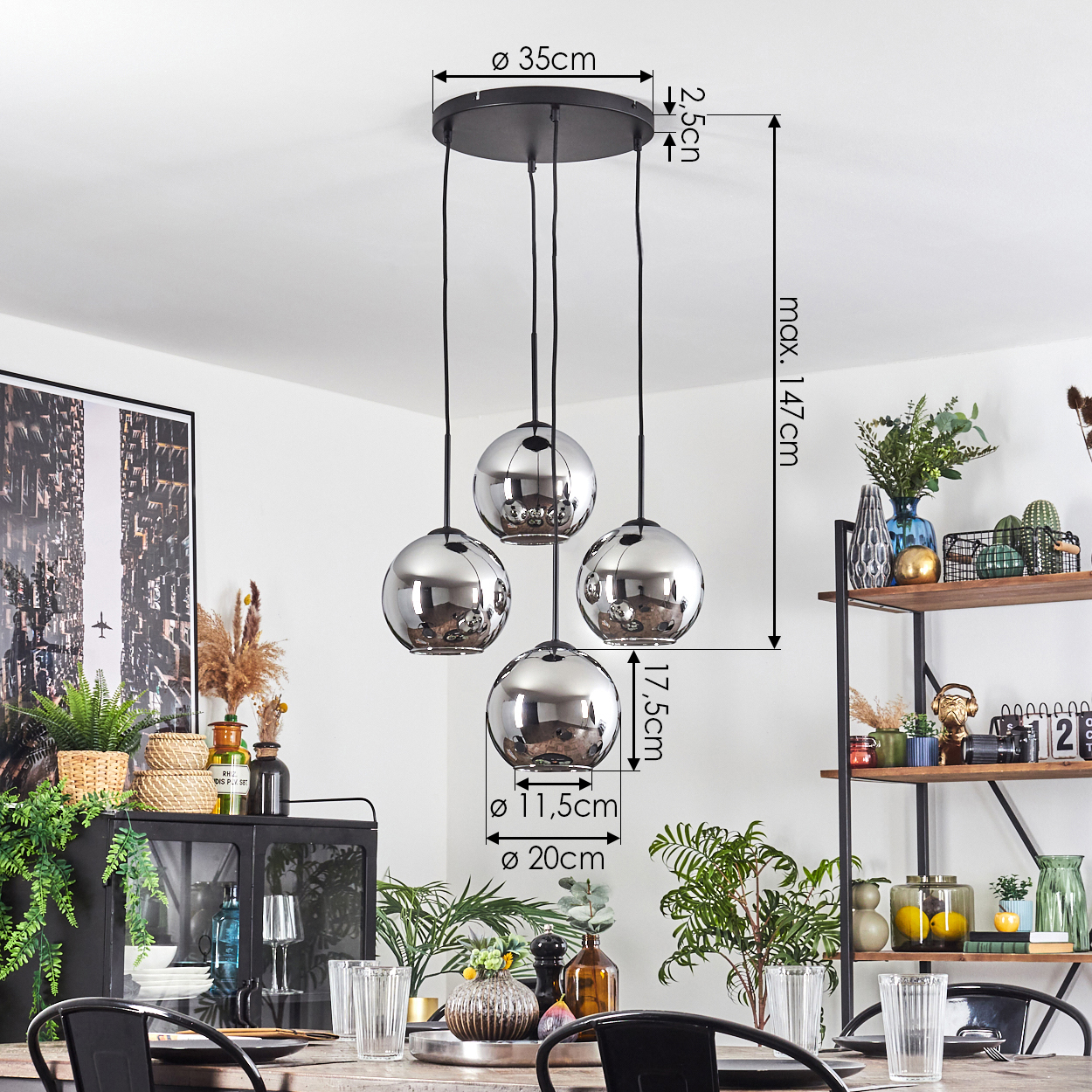 Ein Esszimmer mit einem schwarzen Kronleuchter mit vier kugelförmigen Lichtern. Es gibt einen Tisch, der mit Gläsern zum Abendessen gedeckt ist.
