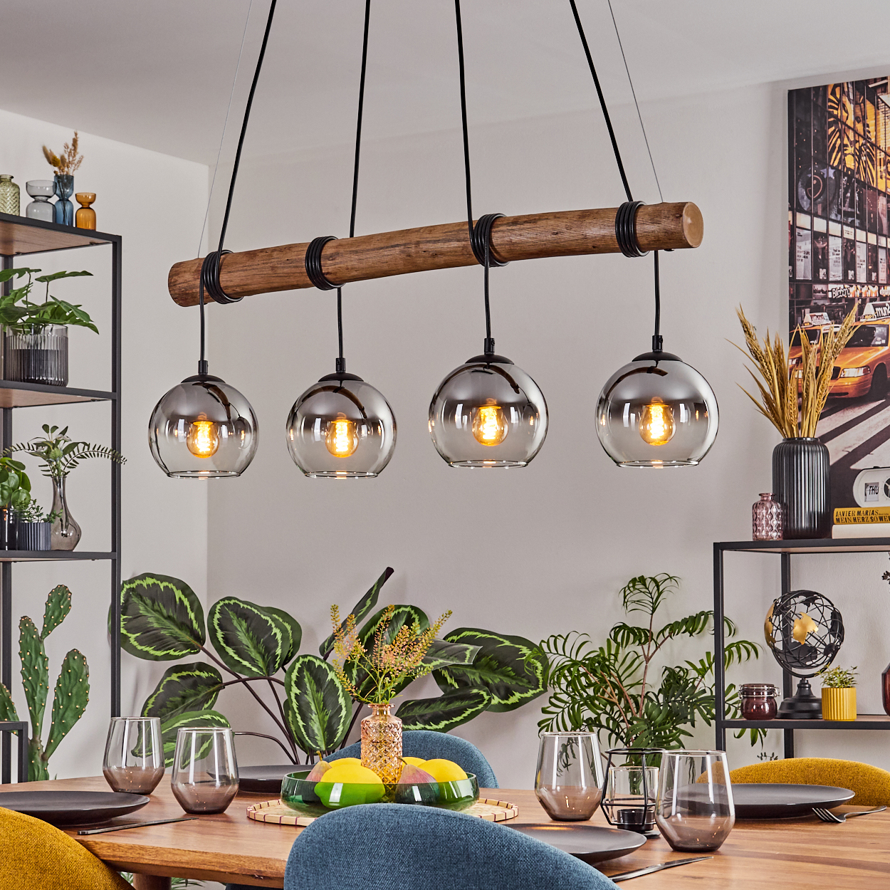 Ein Esszimmer mit Holztisch, Stühlen und Hängelampen mit Glaskugeln. Pflanzen und Dekorationen füllen den Raum.