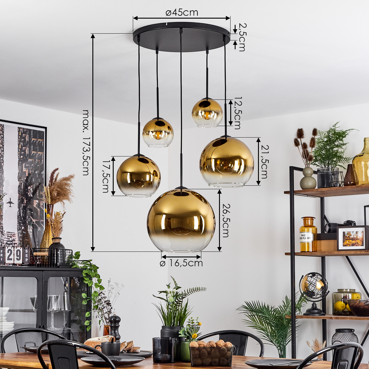 Ein Esszimmer mit Holztisch, schwarzen Stühlen und einer schwarz-goldenen Pendelleuchte. Dekorationen umfassen Pflanzen und ein Regal.