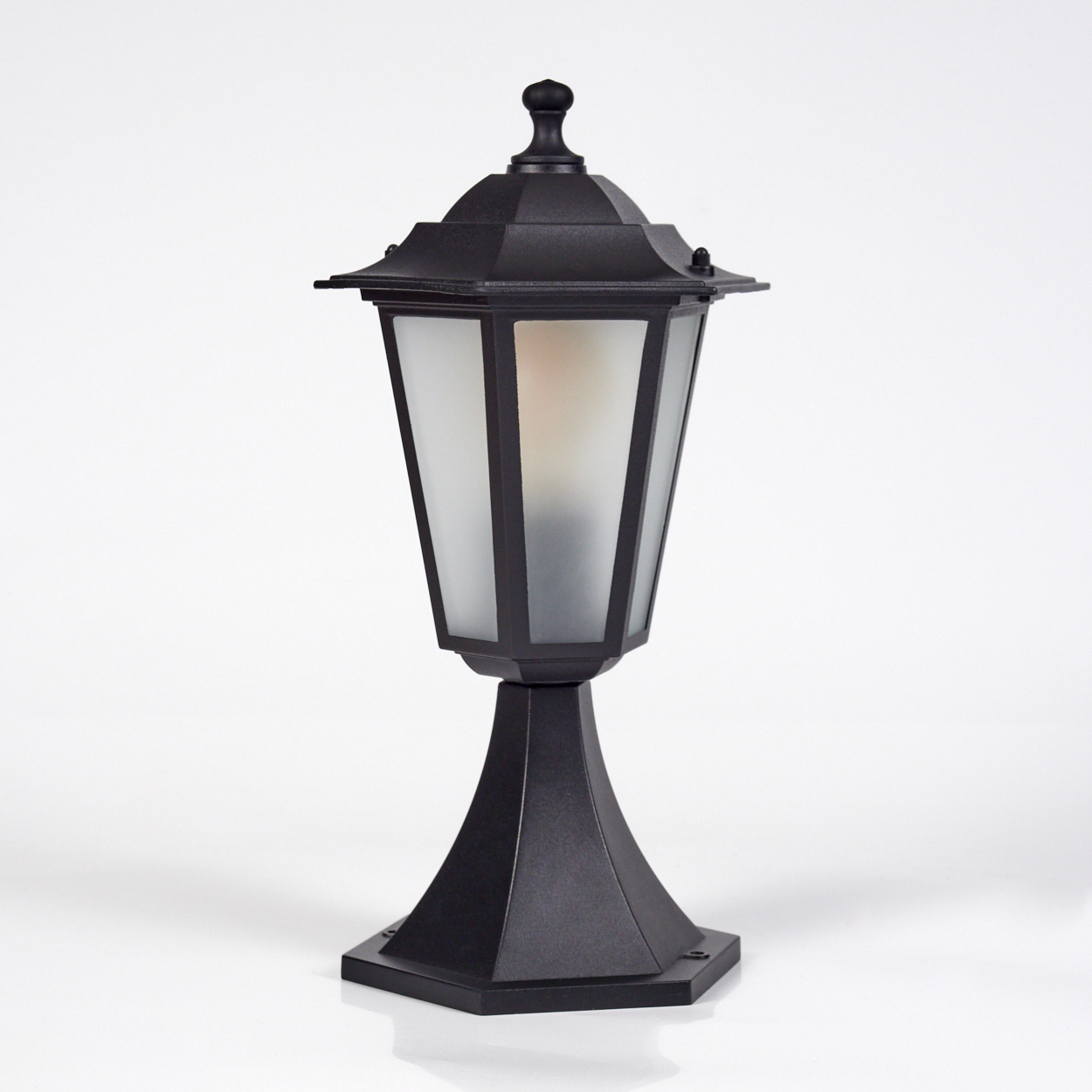 Eine schwarze Außenlampe steht auf weißem Untergrund. Sie hat eine Laternenform mit Milchglasscheiben und einem dekorativen Aufsatz.