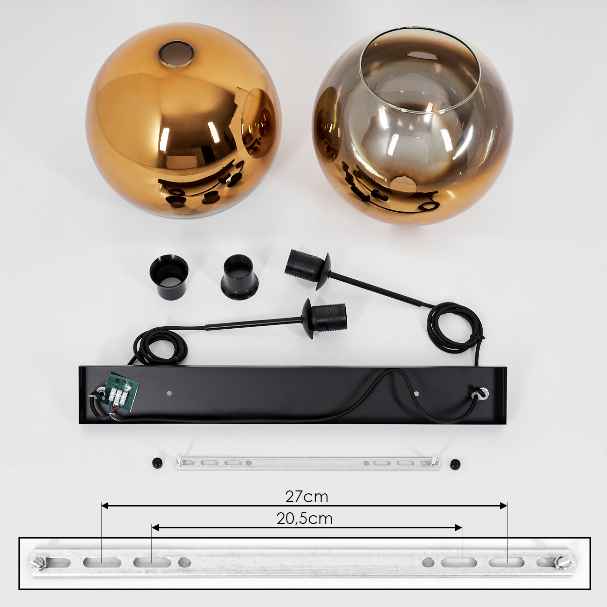 Draufsicht einer zerlegten Lampe. Zwei kugelförmige Glasschirme, schwarze Hardware, eine schwarze Basis und eine Messanleitung sind zu sehen.