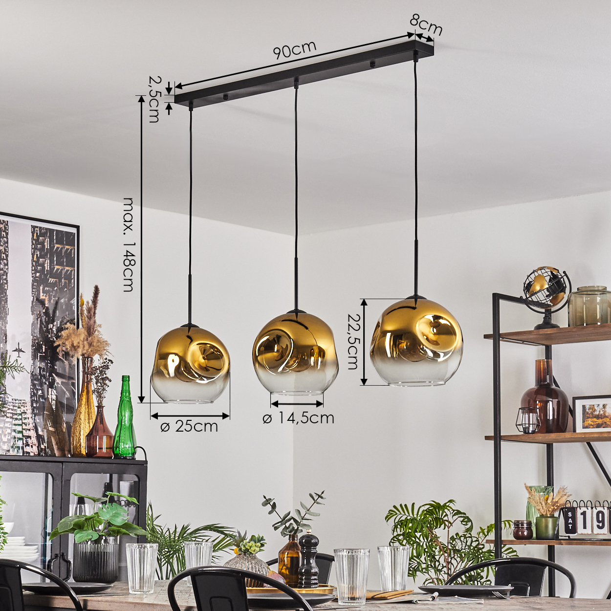 Drei gold- und klarglasfarbene Pendelleuchten hängen über einem Esstisch, der mit Gläsern und schwarzen Stühlen gedeckt ist. Im Hintergrund sind Regale und Pflanzen zu sehen.
