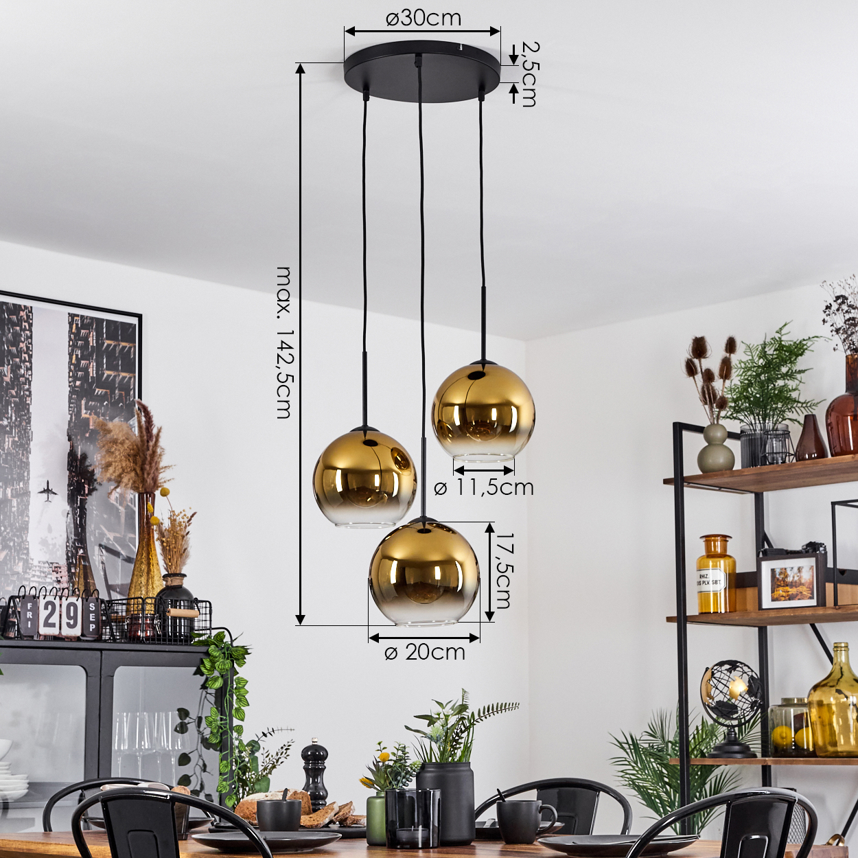 Esszimmer mit schwarzem Kronleuchter mit drei goldenen Kugelleuchten. Ein Holztisch und schwarze Stühle sind im Vordergrund.