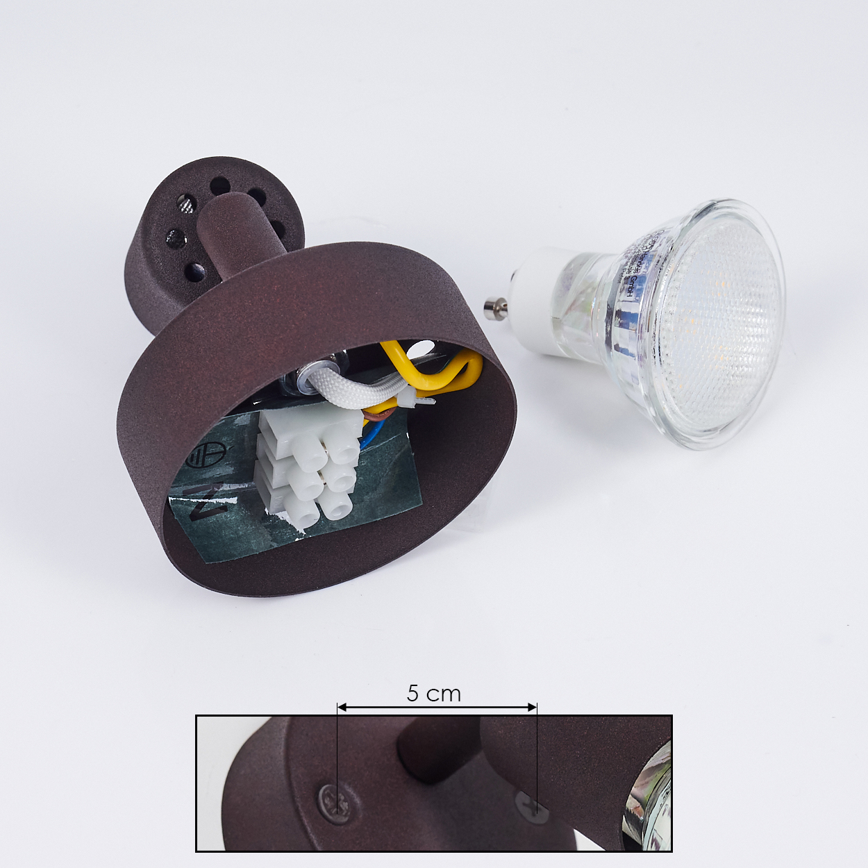 Eine zerlegte braune Außenlampe mit freiliegendem elektrischen Fach und einer separaten Glühbirne auf weißem Hintergrund.