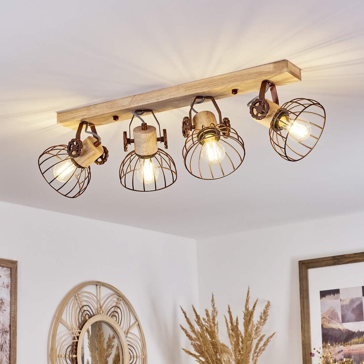 Deckenleuchte mit vier Lampen im Käfigstil. Sie sind an einem Holzbalken befestigt. Der Hintergrund ist eine weiße Decke und Wände.