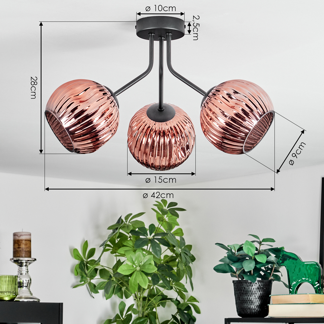 Eine moderne Deckenlampe mit drei kupferfarbenen, gerippten Glaskugeln. Darunter sind Pflanzen und Dekorationsartikel auf einem Regal zu sehen.