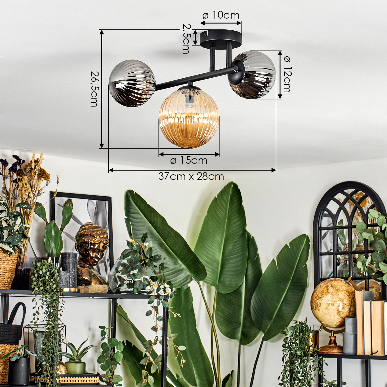 Deckenlampe mit drei Glasschirmen, schwarzer Rahmen. Pflanzen, Globus, Bücher und gerahmte Kunst im Hintergrund.