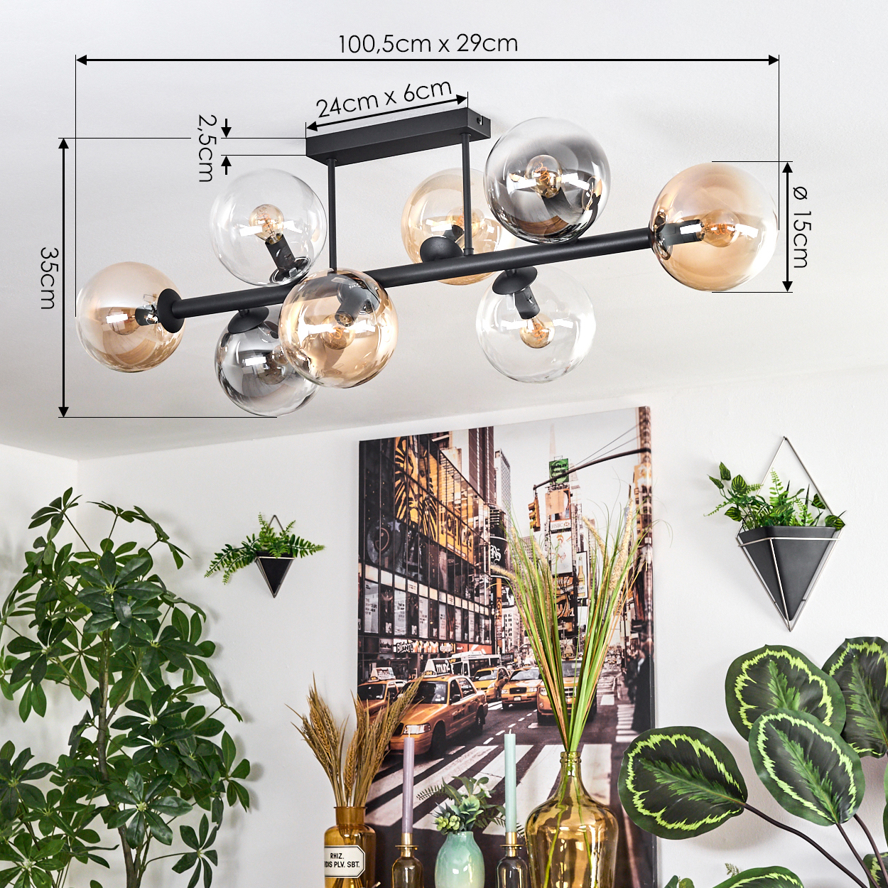 Eine moderne Deckenlampe mit mehreren Glaskugeln. Der Hintergrund zeigt ein Straßenbild und einige Pflanzen.