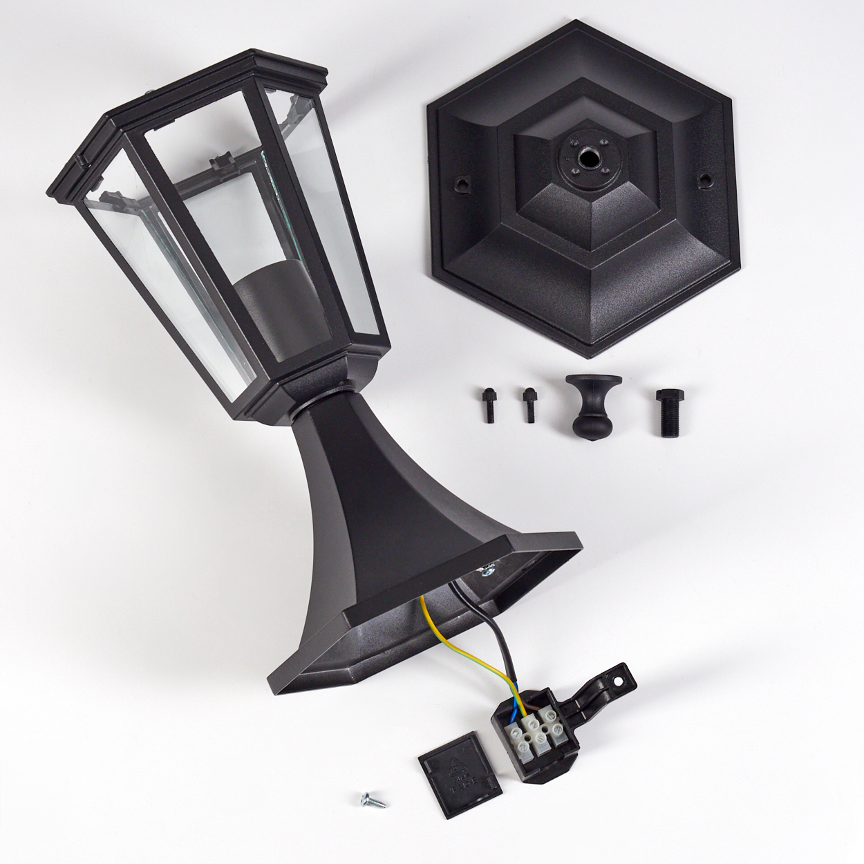 Schwarze zerlegte Außenlampe auf weißem Hintergrund. Teile umfassen Lampe, Sockel, Schrauben und Verdrahtungskomponenten.