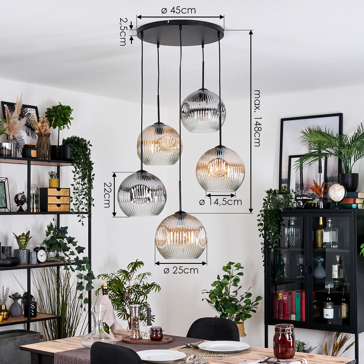 Esszimmer mit Kronleuchter mit fünf Glaskugelleuchten. Ein Tisch ist gedeckt, und ein Regal mit Pflanzen ist im Hintergrund.