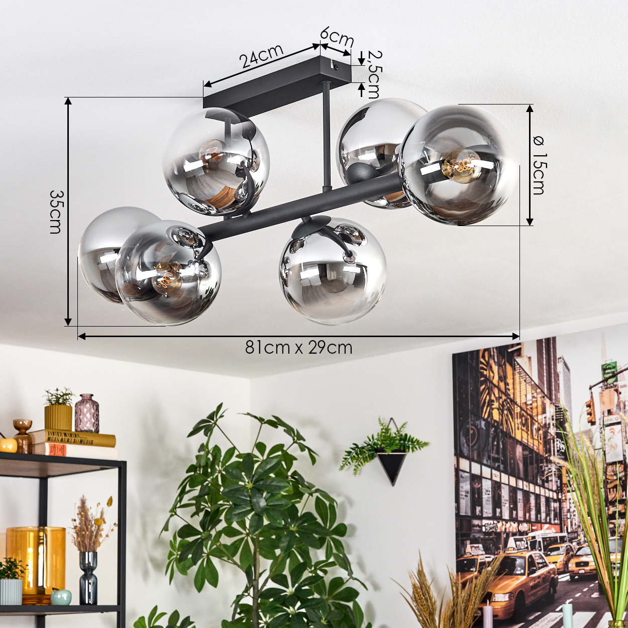 Eine moderne Deckenlampe mit sechs Chromkugeln. Darunter sind eine Pflanze und ein Stadtbildgemälde zu sehen.