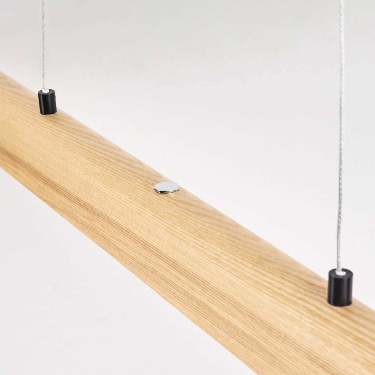 Nahaufnahme eines Holzbalkens mit Metallakzenten und Hängedrähten vor weißem Hintergrund.