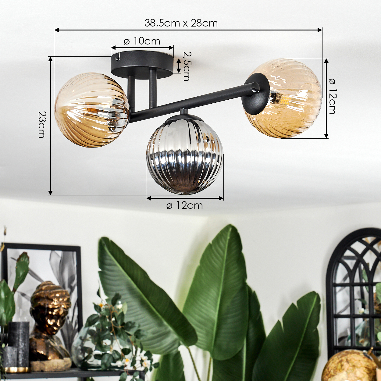 Eine moderne Deckenlampe mit drei Glaskugeln, zwei bernsteinfarben und einer silbernen, mit schwarzem Rahmen. Abmessungen sind sichtbar.