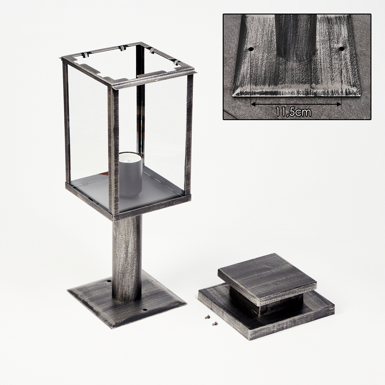 Zerlegte metallische Laterne mit Glasscheiben. Teile umfassen eine Basis, einen Deckel und eine zylindrische Stütze. Der Hintergrund ist weiß.