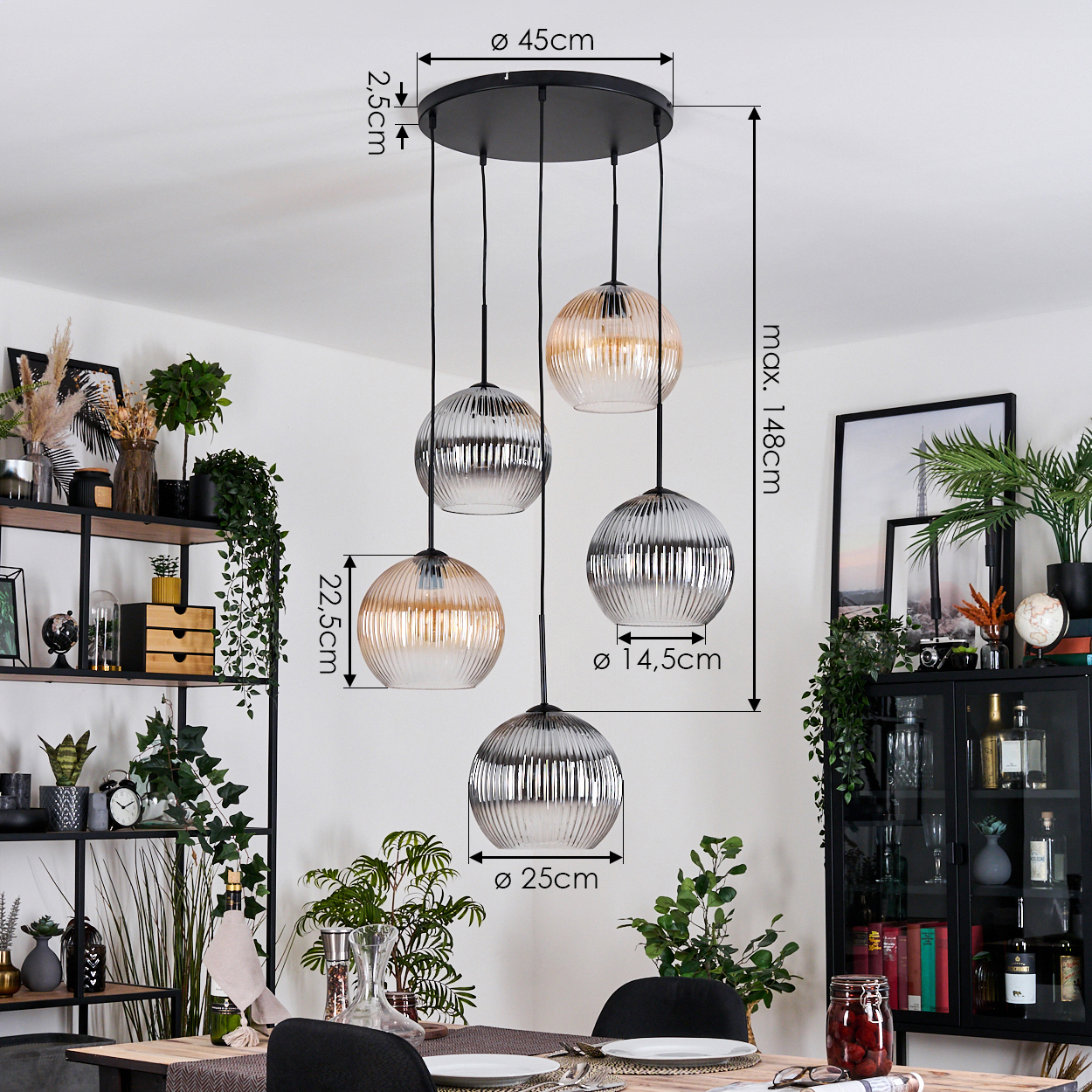Ein Esszimmer mit gedecktem Tisch. Über dem Tisch hängen fünf Glaskugel-Pendelleuchten. Pflanzen und Dekorationen füllen den Hintergrund.