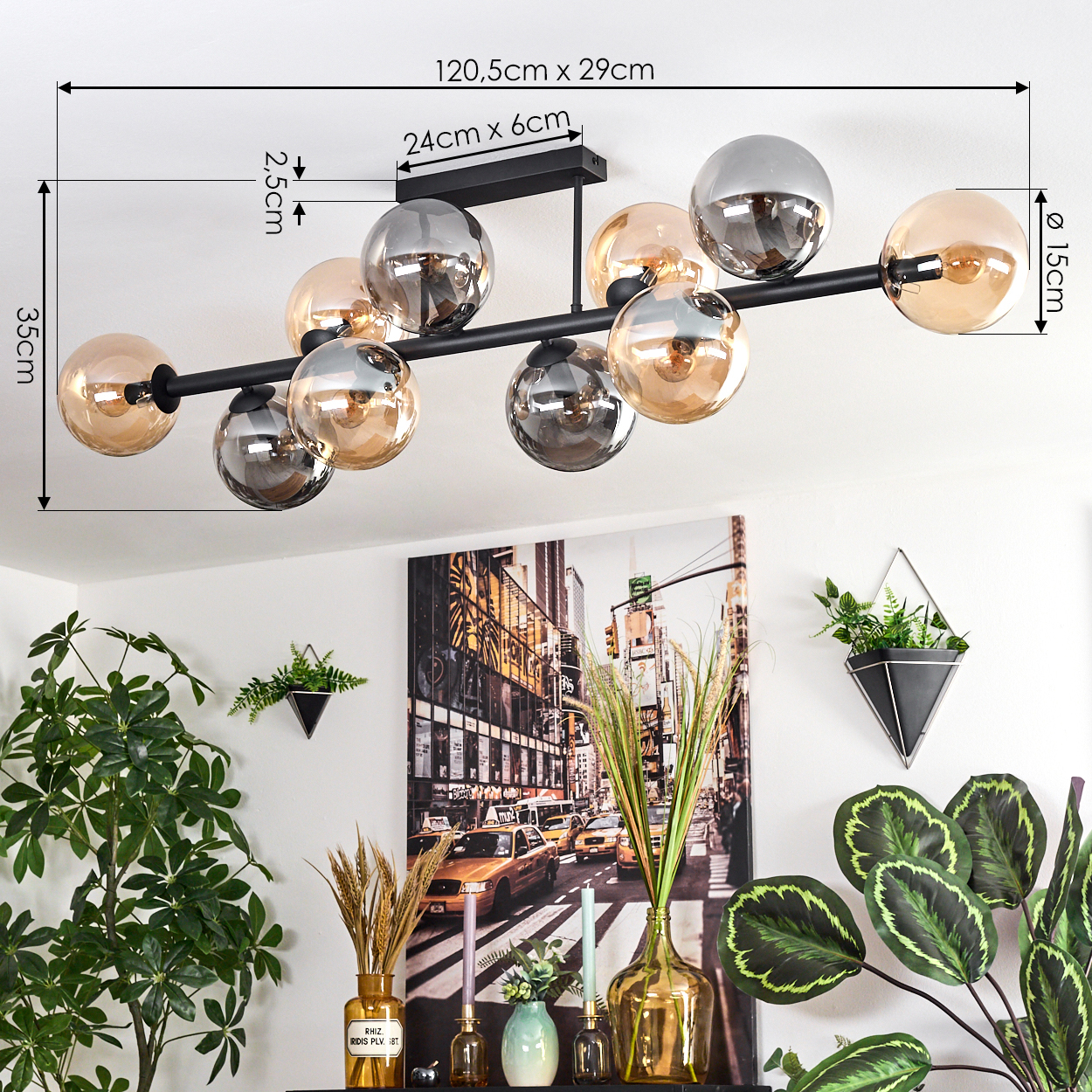 Eine moderne schwarze Deckenlampe mit mehreren Glaskugeln. Darunter ein Stadtbild mit Pflanzen und Vasen auf einem Regal.