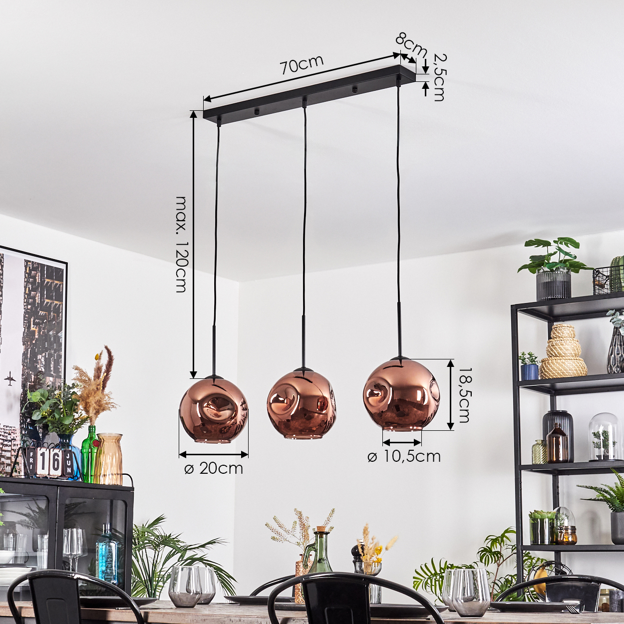 Ein modernes Interieur mit drei kupferfarbenen Pendelleuchten, die an einer schwarzen Stange hängen. Abmessungen sind angegeben, Pflanzen und Möbel sind sichtbar.