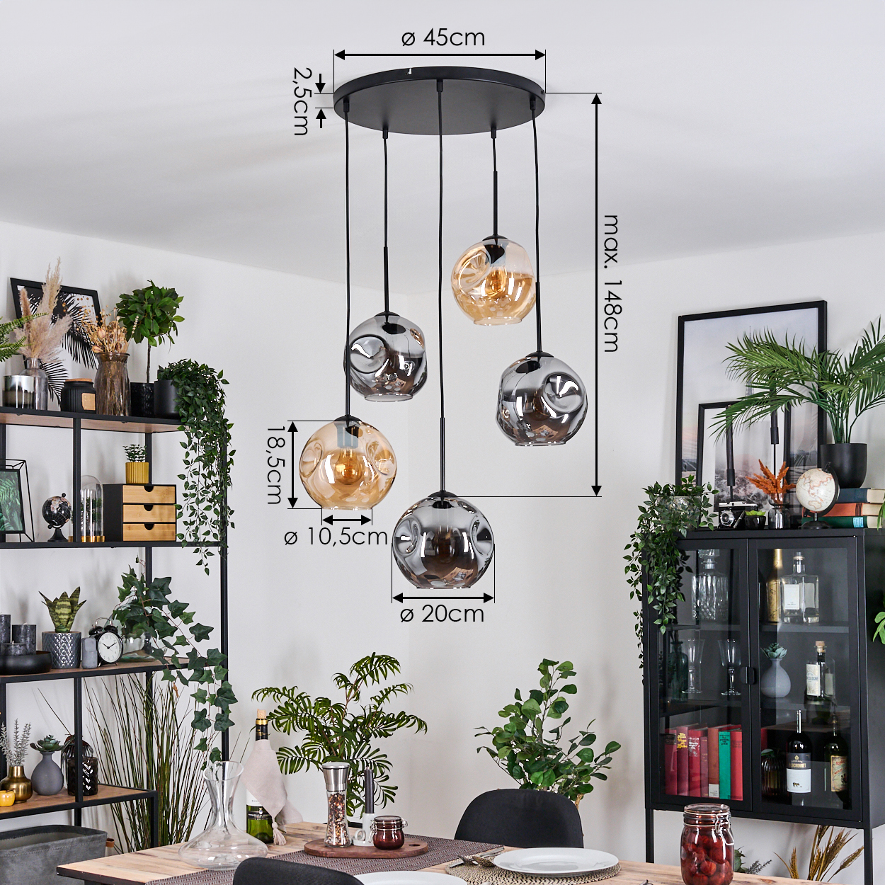 Ein modernes Esszimmer mit einem schwarzen Kronleuchter mit fünf Glaskugelleuchten. Pflanzen und Möbel sind ebenfalls im Raum zu sehen.