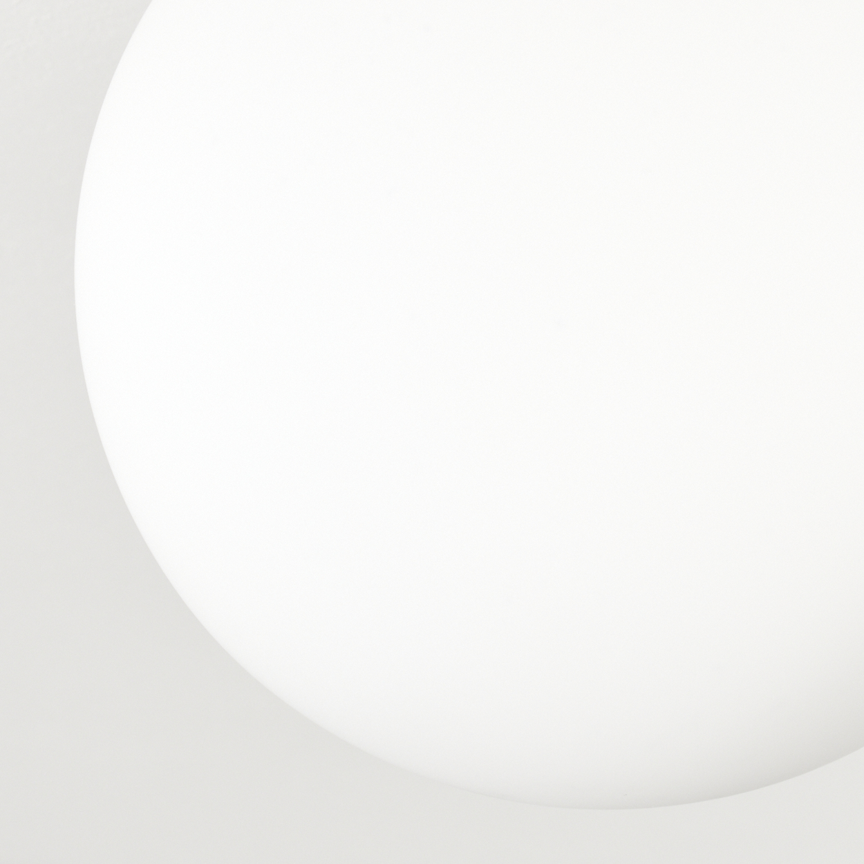 Eine weiße, abgerundete Form dominiert das Bild, mit einer gekrümmten Kante vor einem hellgrauen Hintergrund. Es deutet auf eine glatte Oberfläche hin.