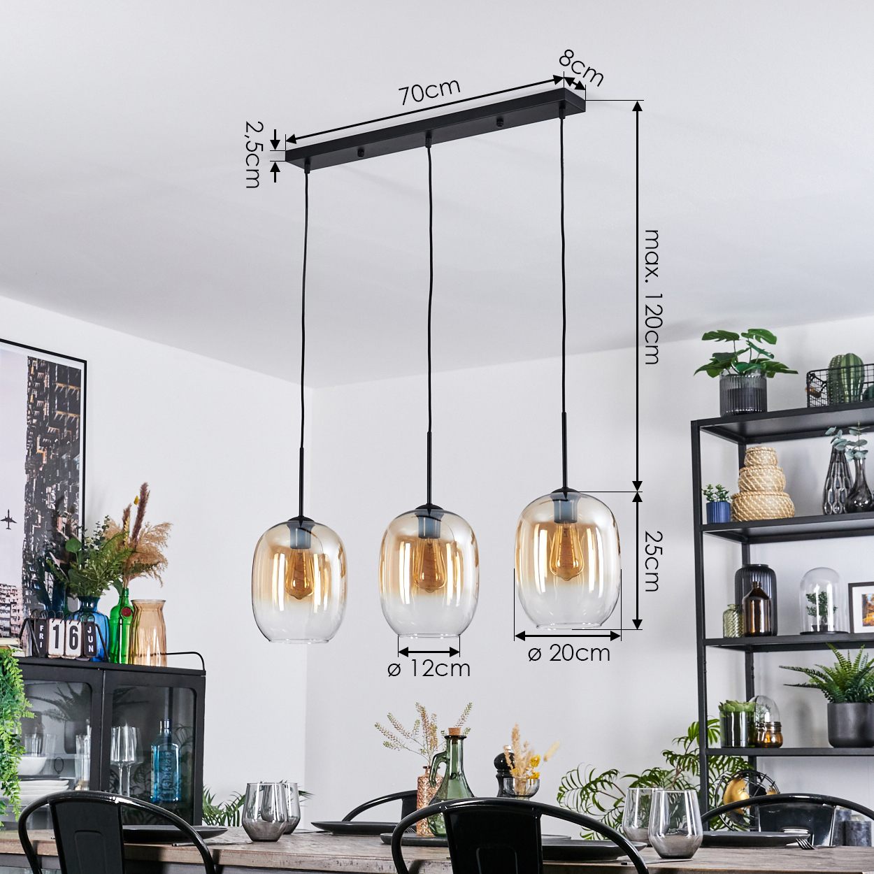 Drei Pendelleuchten mit bernsteinfarbenen Glasschirmen hängen über einem Tisch. Maße sind angegeben. Pflanzen und Deko im Hintergrund.