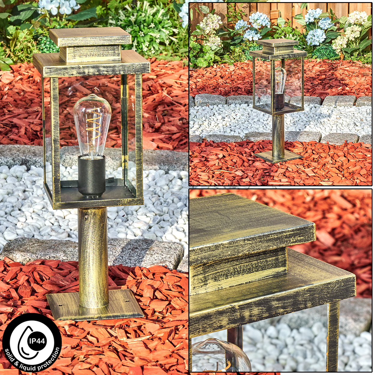 Eine goldene Außenlampe mit Glasgehäuse und Vintage-Glühbirne, eingebettet in einen Garten mit roter Mulche, weißen Steinen und Pflanzen.