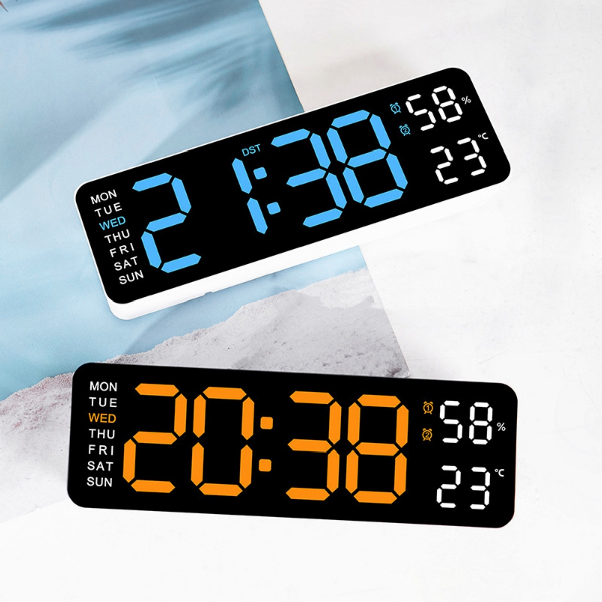 Zwei Digitaluhren mit Zeit, Luftfeuchtigkeit und Temperatur. Eine zeigt 2:38, die andere 20:38. Beide haben einen schwarzen Hintergrund.