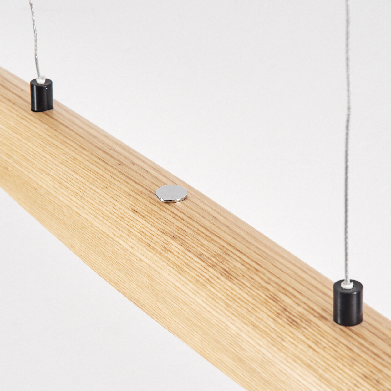 Holzbalken mit metallischen Akzenten und Drähten, die daran hängen. Schwarze Zylinder und silberne Scheiben sind befestigt.