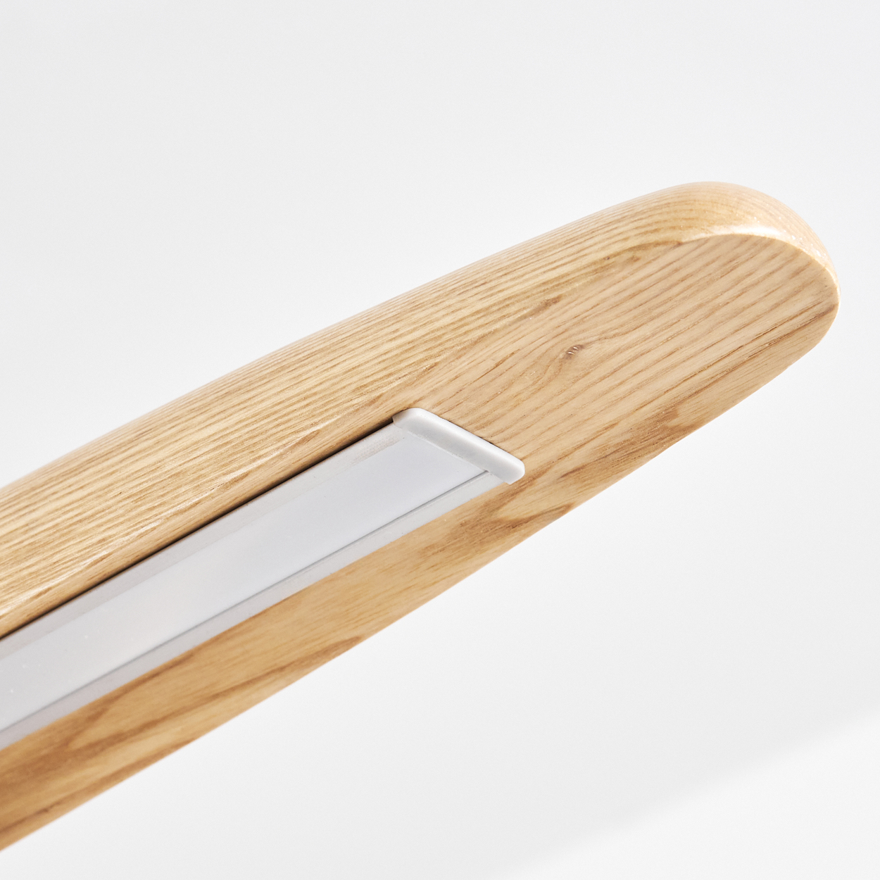 Nahaufnahme eines Holzbalkens mit einem weißen Lichtstreifen. Das Holz ist hellbraun mit sichtbarer Maserung. Der Hintergrund ist weiß.