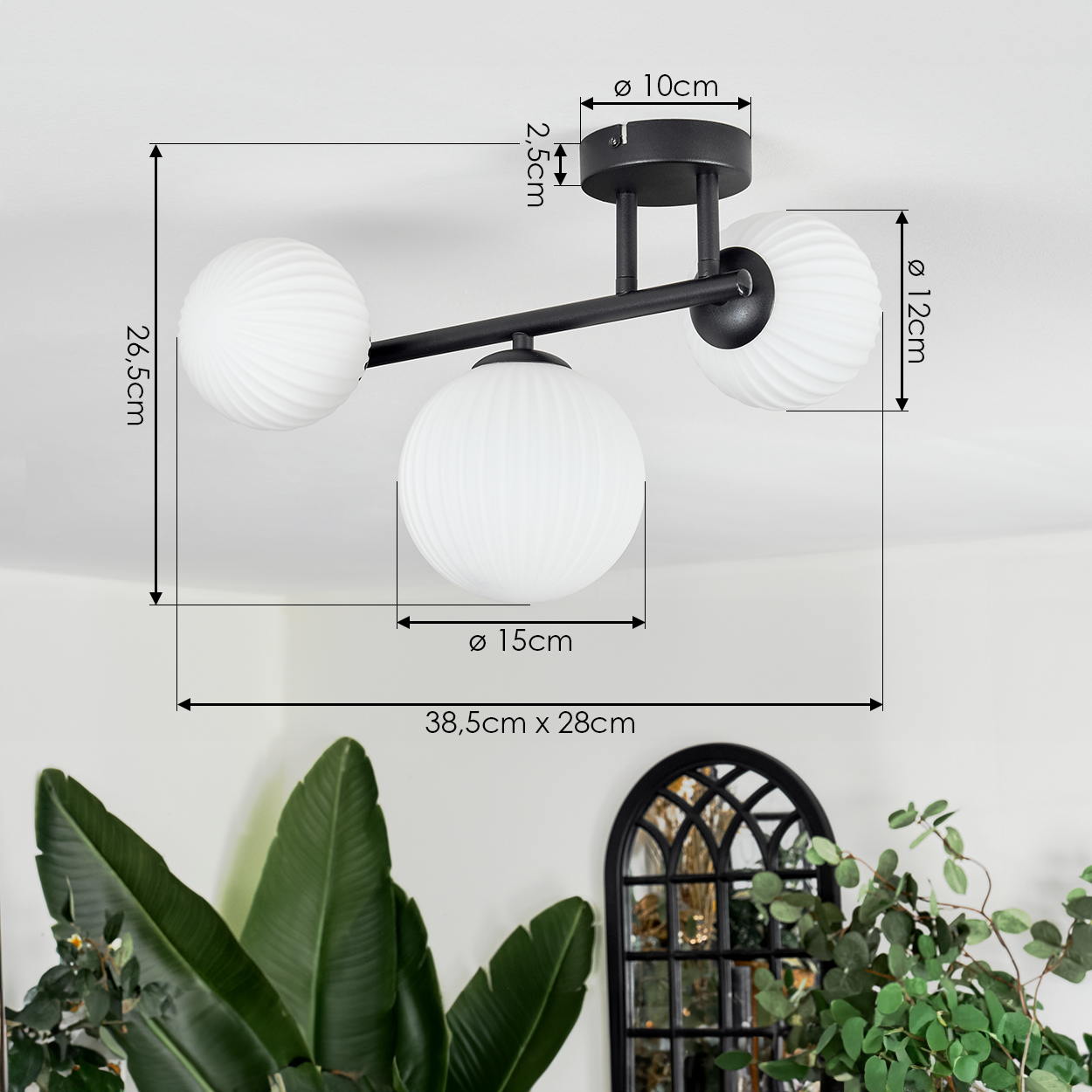 Moderne Deckenlampe mit drei weißen, geriffelten Glaskugeln. Schwarzer Metallrahmen. Maße werden angezeigt. Pflanzen und Dekoration im Hintergrund.