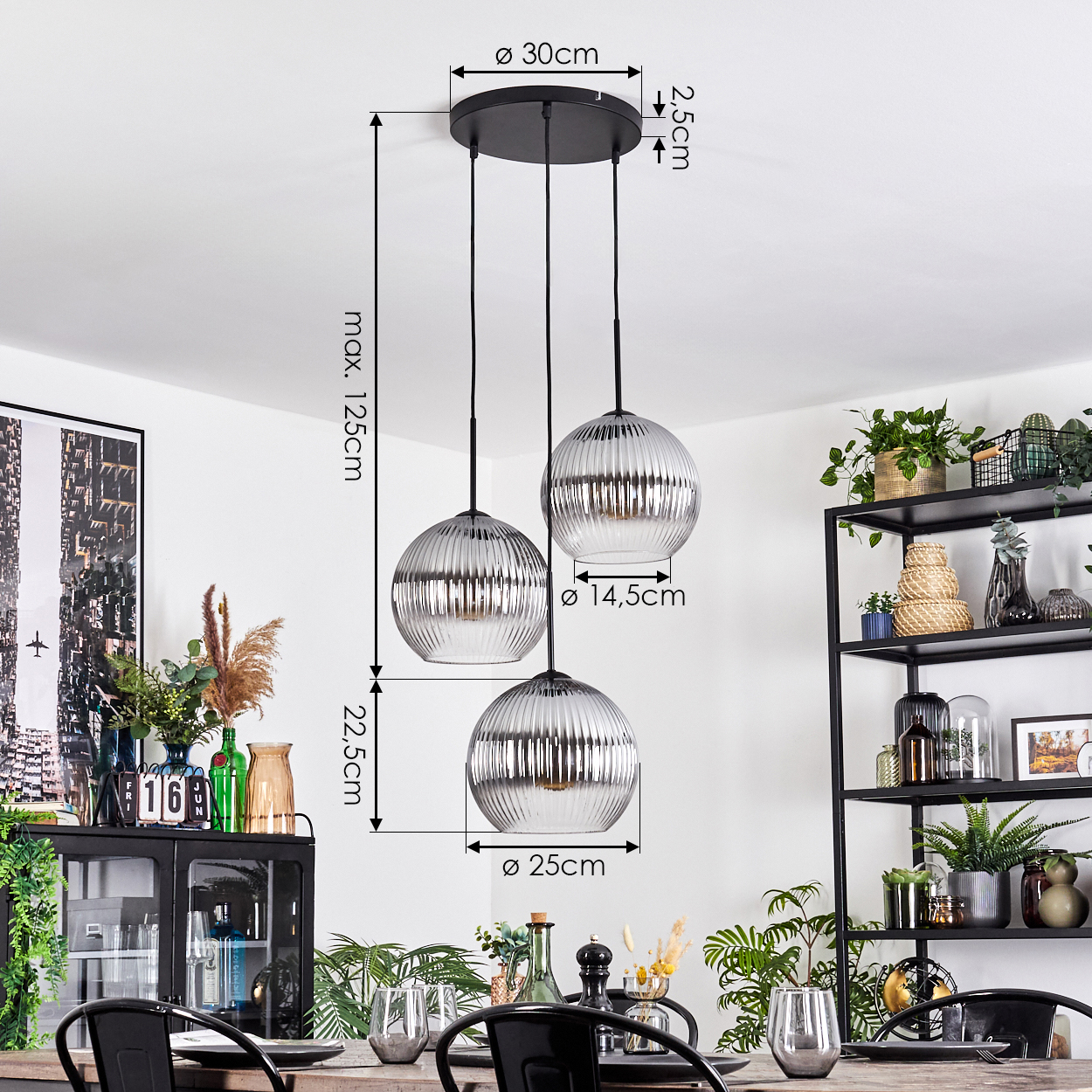 Drei Pendelleuchten mit runden, gerippten Glasschirmen hängen über einem Tisch. Maße sind angegeben. Pflanzen und Deko sind im Hintergrund.