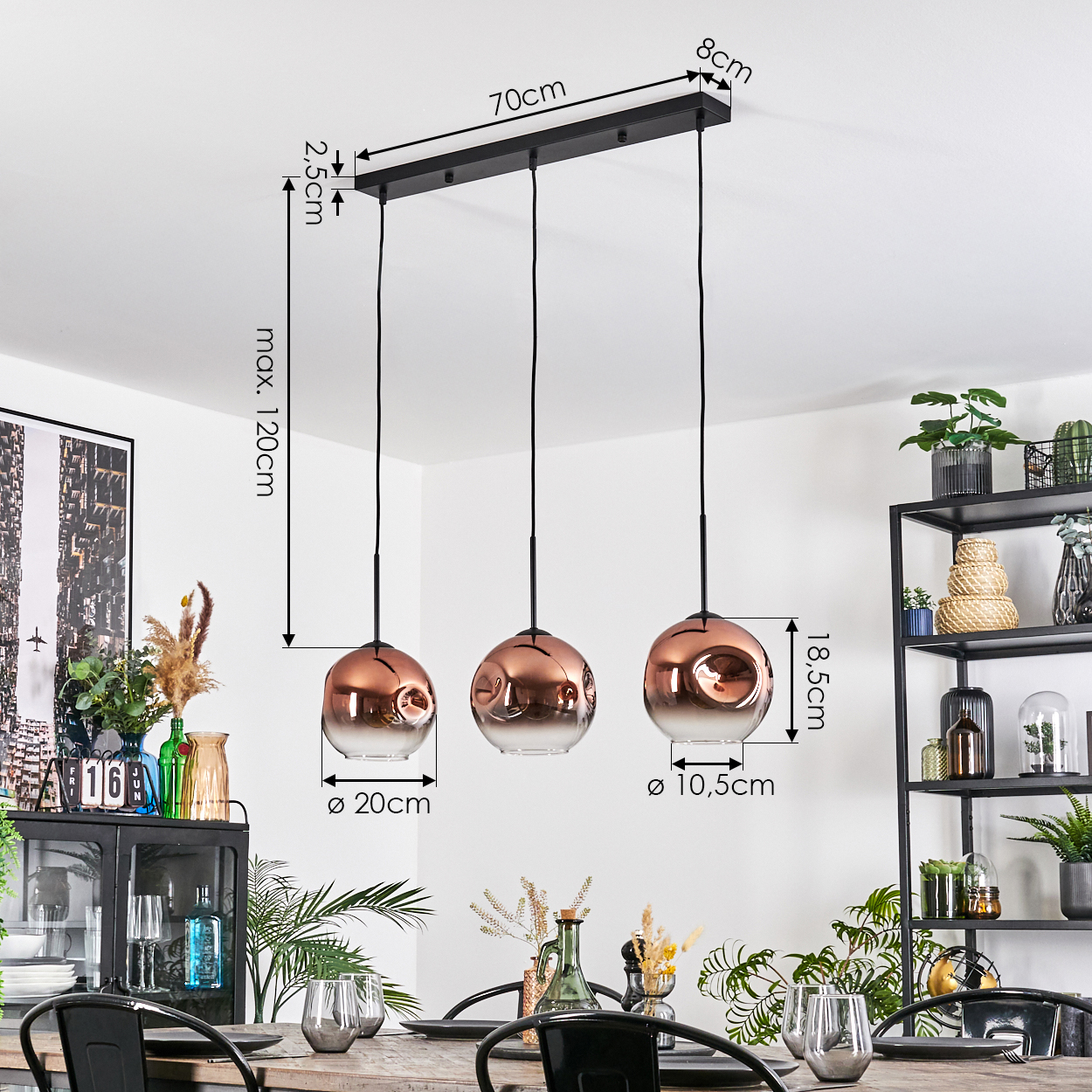 Drei kupferfarbene Pendelleuchten hängen über einem Esstisch. Abmessungen sind angegeben. Pflanzen und ein schwarzes Metallregal im Hintergrund.