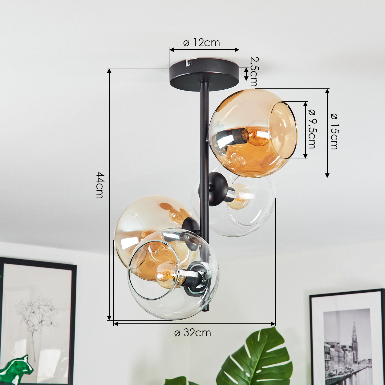 Moderne Deckenlampe mit drei kugelförmigen Glasschirmen, zwei bernsteinfarben und einer klaren, an einem schwarzen Rahmen befestigt.