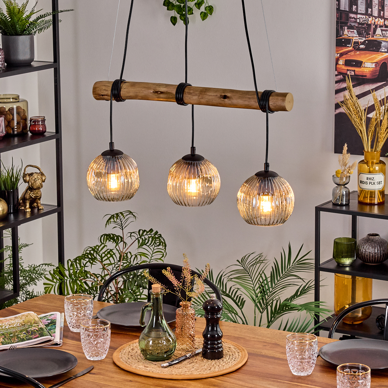 Esszimmer mit Holztisch, Hängelampen und Tischdeko. Pflanzen und Dekoration im Hintergrund.