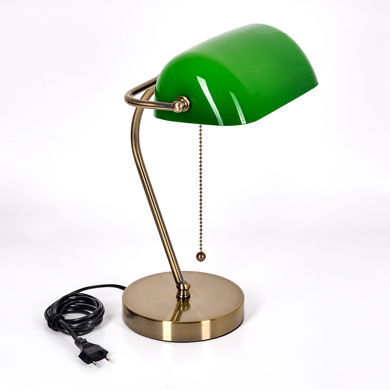 Eine grün schattierte Schreibtischlampe aus Messing auf weißem Hintergrund. Die Lampe ist an, mit einer Zugkette und einem schwarzen Kabel.