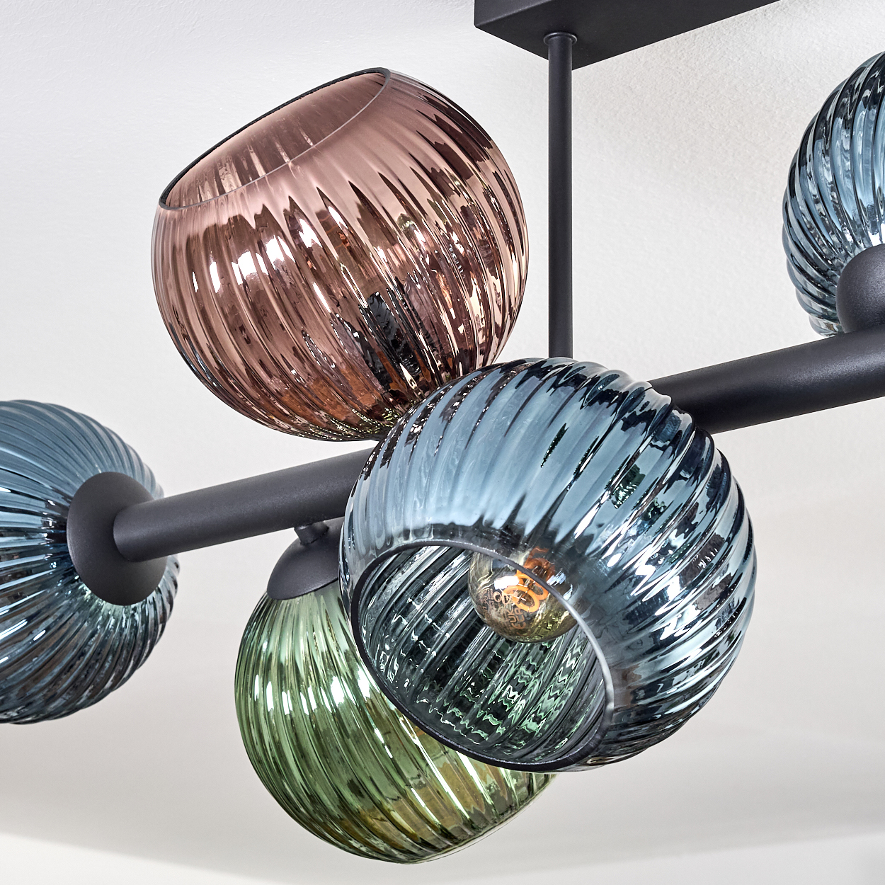 Eine moderne Deckenleuchte mit sechs farbigen Glaskugeln. Die Farben sind Blau, Grün und Rosa. Die Halterung ist schwarz, vor weißem Hintergrund.