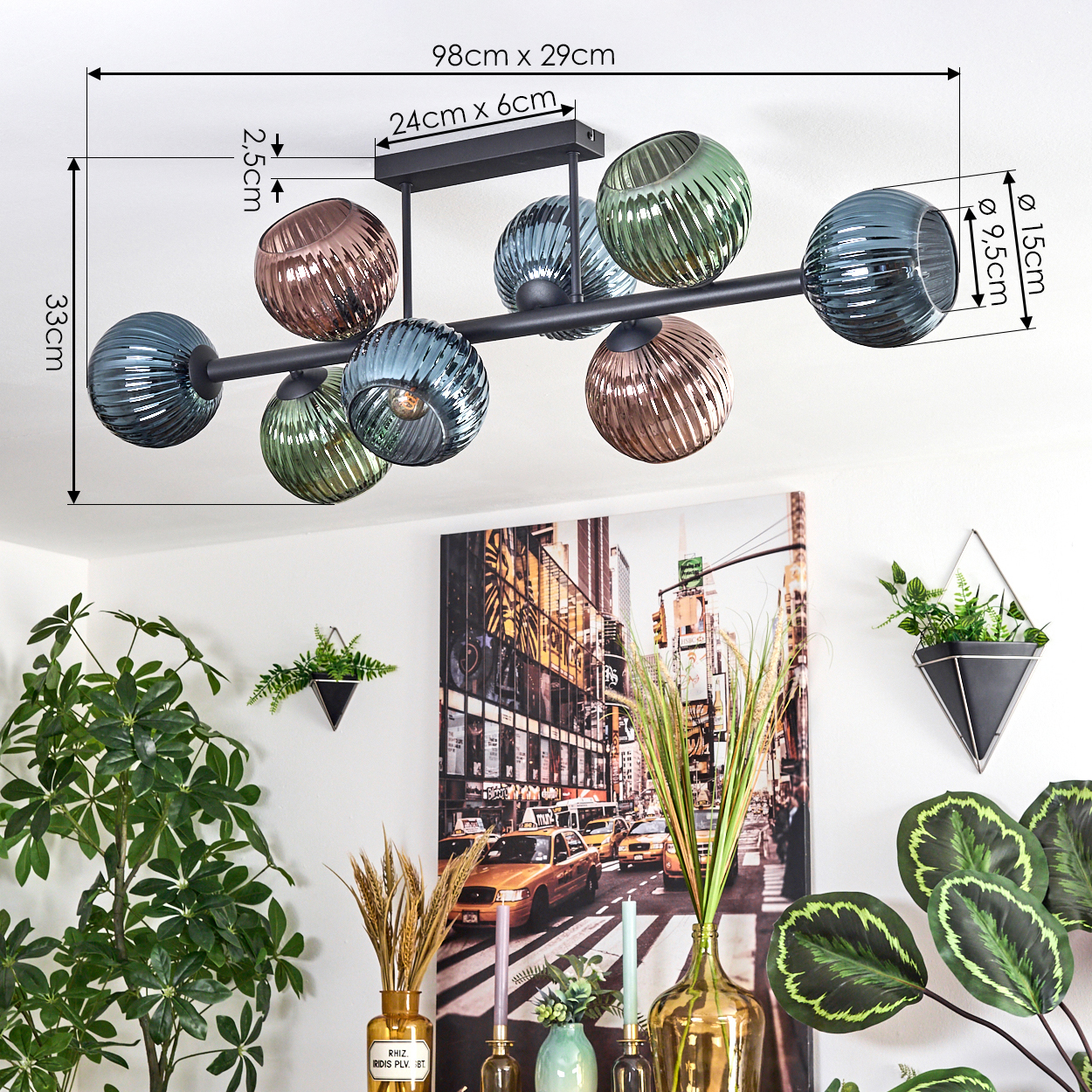 Eine moderne Deckenlampe mit farbigen Glaskugeln hängt über einem Raum, der mit Pflanzen und einem Stadtbild gemalt ist.