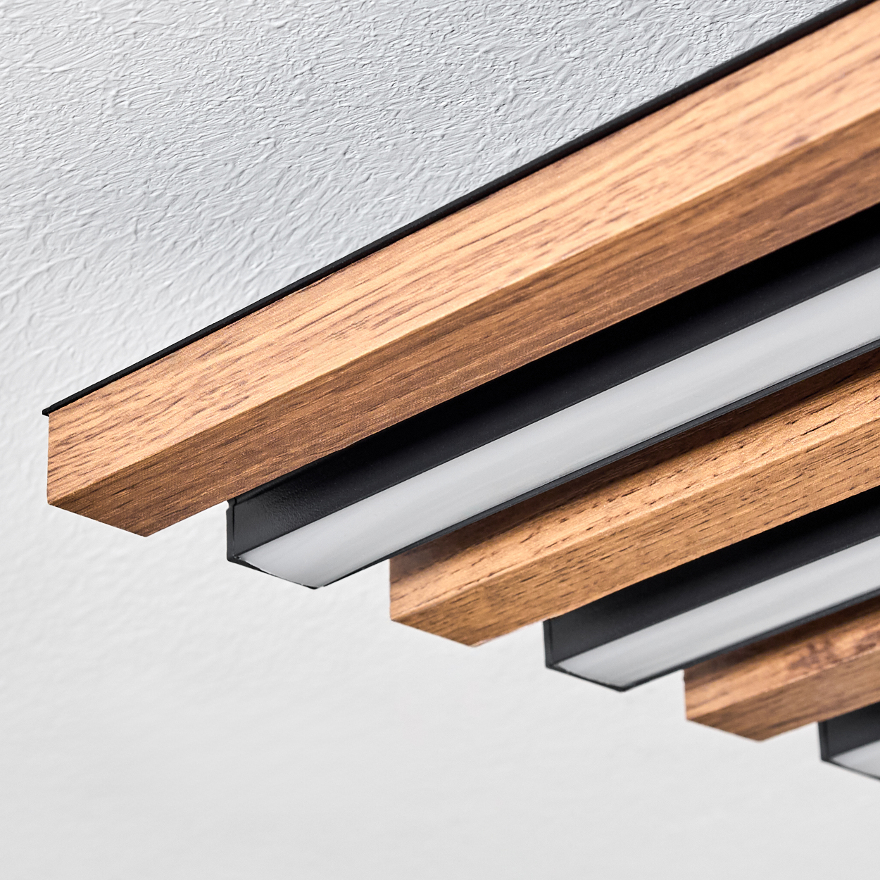 Holzdeckenpaneele mit schwarzen Rändern und weißen Lichtstreifen. Die Decke ist weiß und strukturiert.