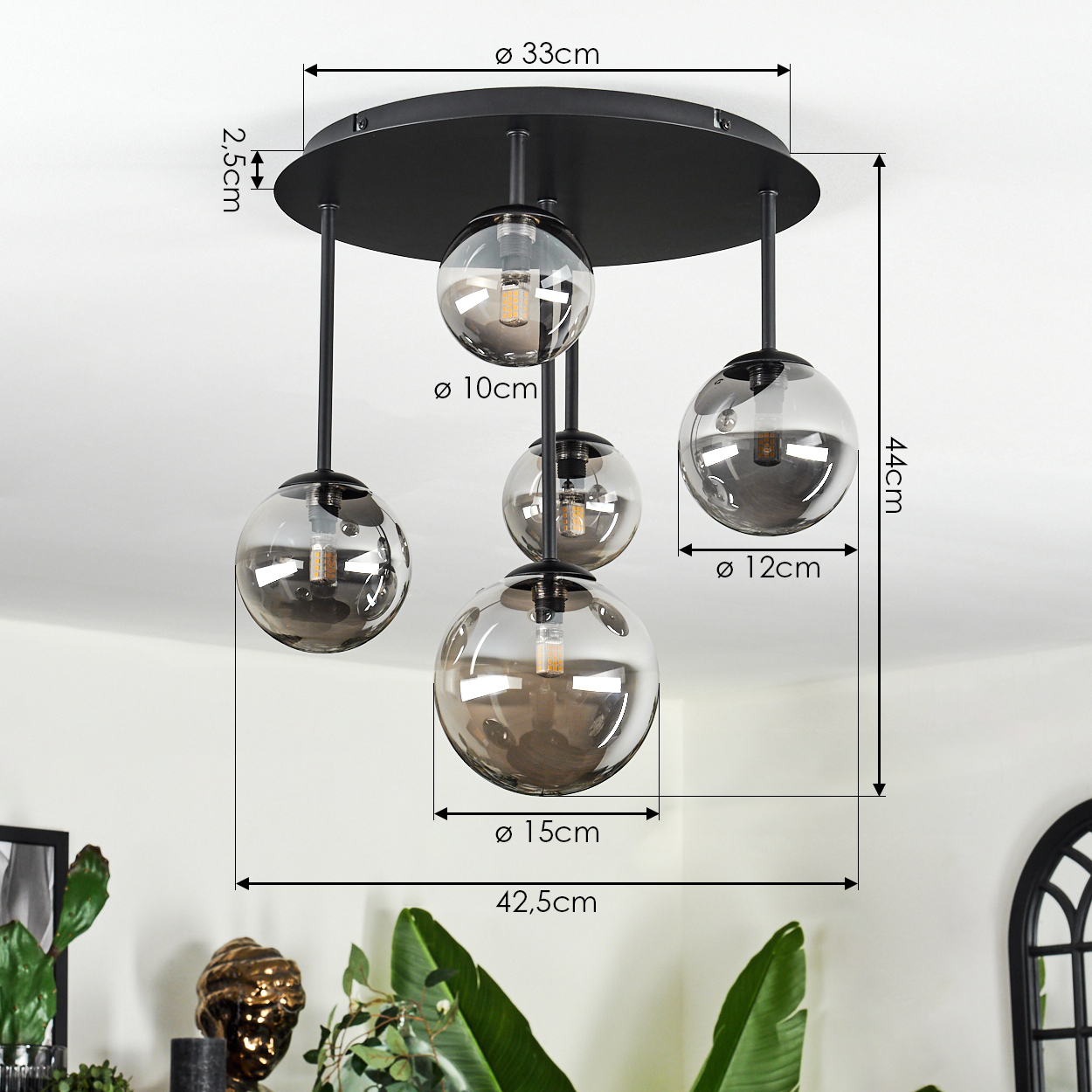 Eine moderne schwarze Deckenlampe mit fünf unterschiedlich großen Glaskugeln. Maße sind im gesamten Bild angegeben.