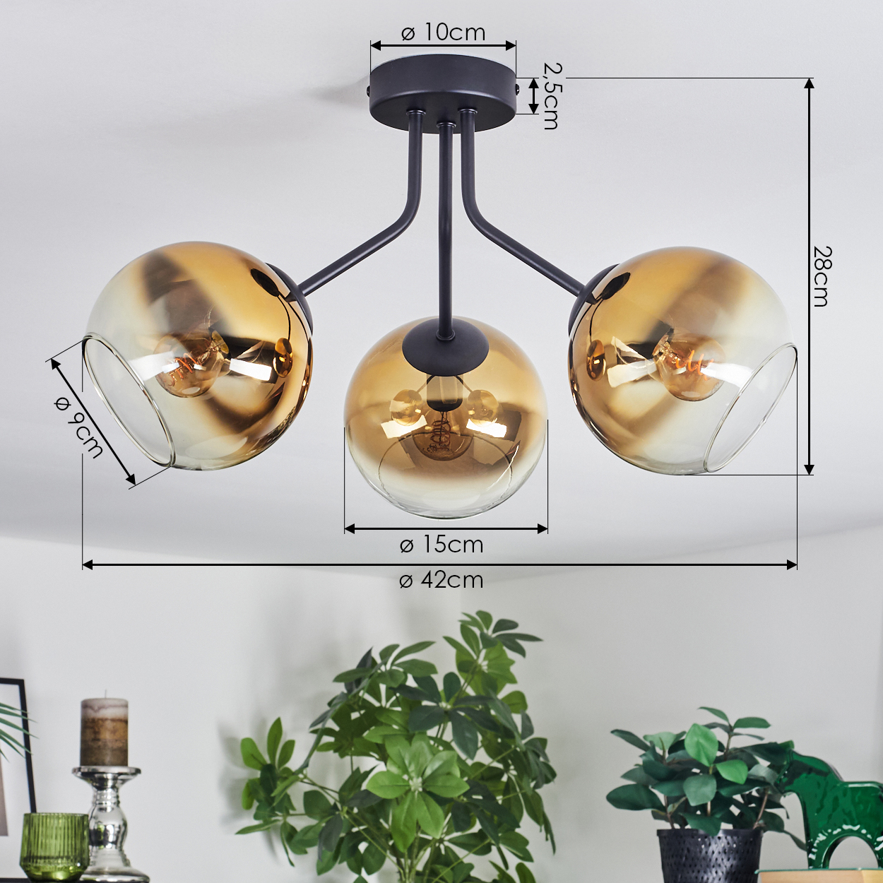 Eine moderne Deckenlampe mit drei kugelförmigen Schirmen. Jede hat eine Glühbirne. Die Schirme sind goldfarben, die Basis schwarz.