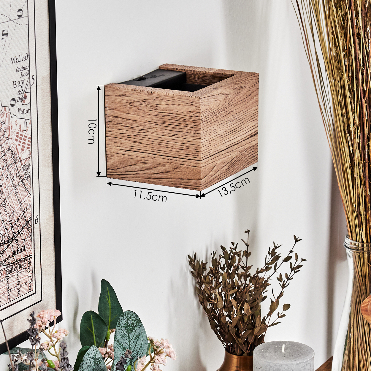 Eine Holzkiste mit Abmessungen ist an einer weißen Wand befestigt. Eine Karte und dekorative Elemente wie Trockenblumen sind sichtbar.