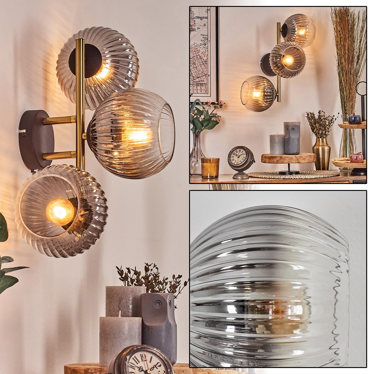 Eine dekorative Wandlampe mit drei Glaskugeln. Auf einer Holzoberfläche sind verschiedene Kerzen, eine Uhr und Pflanzen zu sehen.