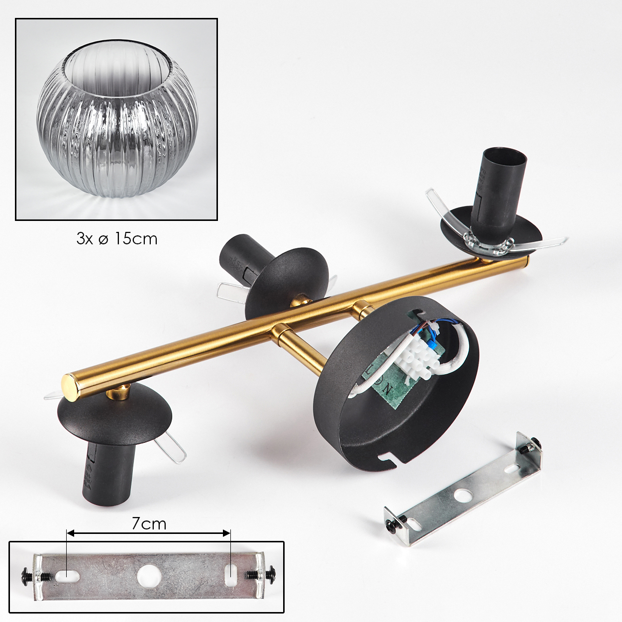 Eine zerlegte Deckenleuchte mit Goldstange, schwarzen Fassungen und Metallhalterung auf weißem Grund. Eine Glasschale ist in der Ecke.