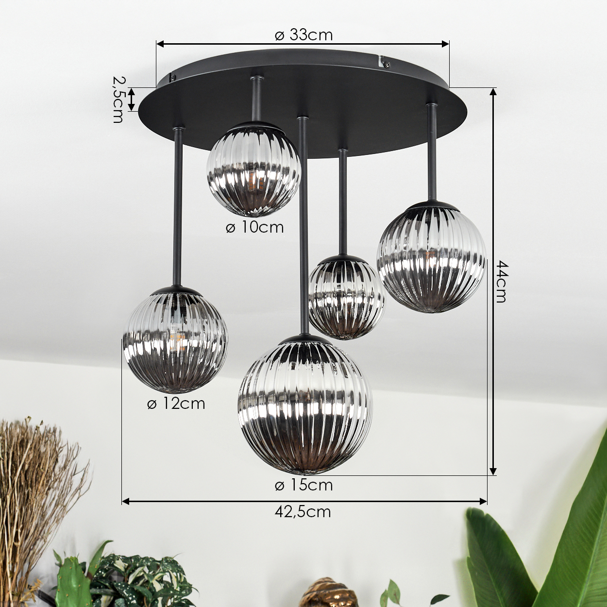 Eine moderne Pendelleuchte mit fünf kugelförmigen Glasschirmen, die von einer schwarzen runden Basis abgehängt sind. Maße sind angegeben.