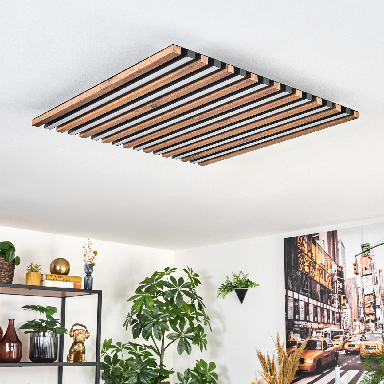 Moderne Deckenleuchte mit Holzlatten. Der Raum zeigt Pflanzen, Regale mit Dekoration und ein Foto von New York City.